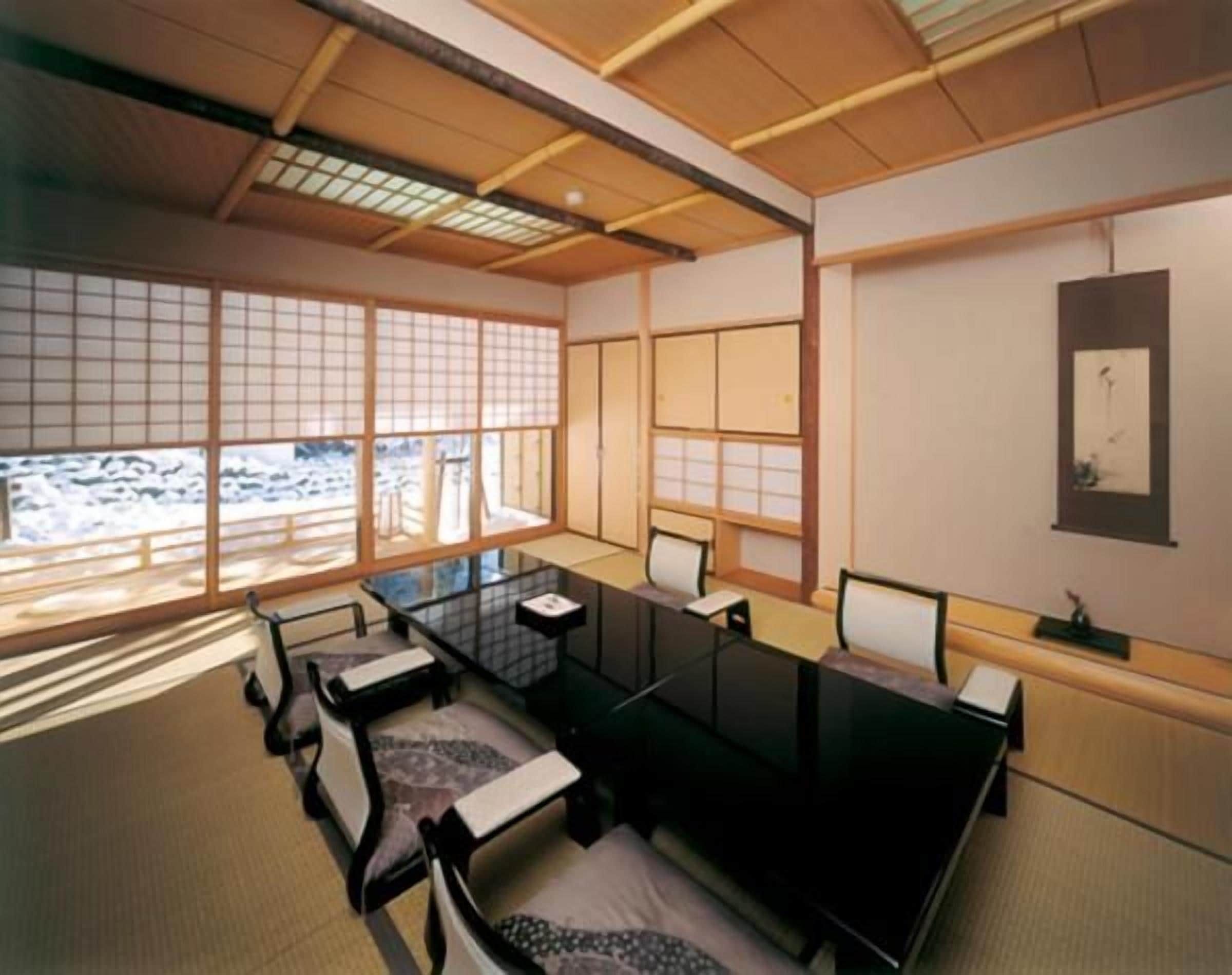 Une pièce de style japonais traditionnel, avec un sol recouvert de tatamis, une table basse et des portes coulissantes.