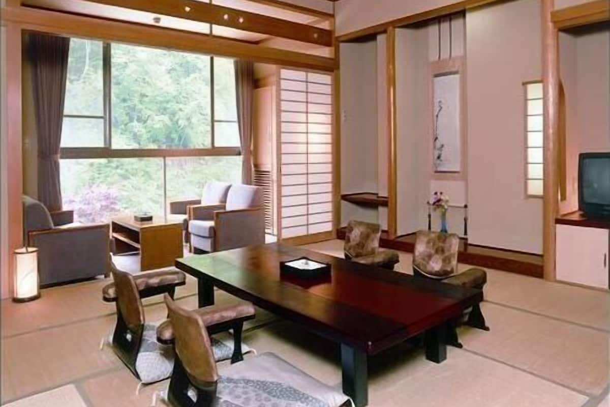 Une pièce de style japonais traditionnel, avec un sol recouvert de tatamis, une table basse et des paravents en papier de riz (shoji).
