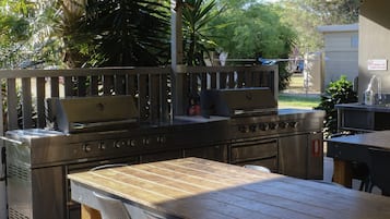 En uteplats med grill, sittplats och en diskho.