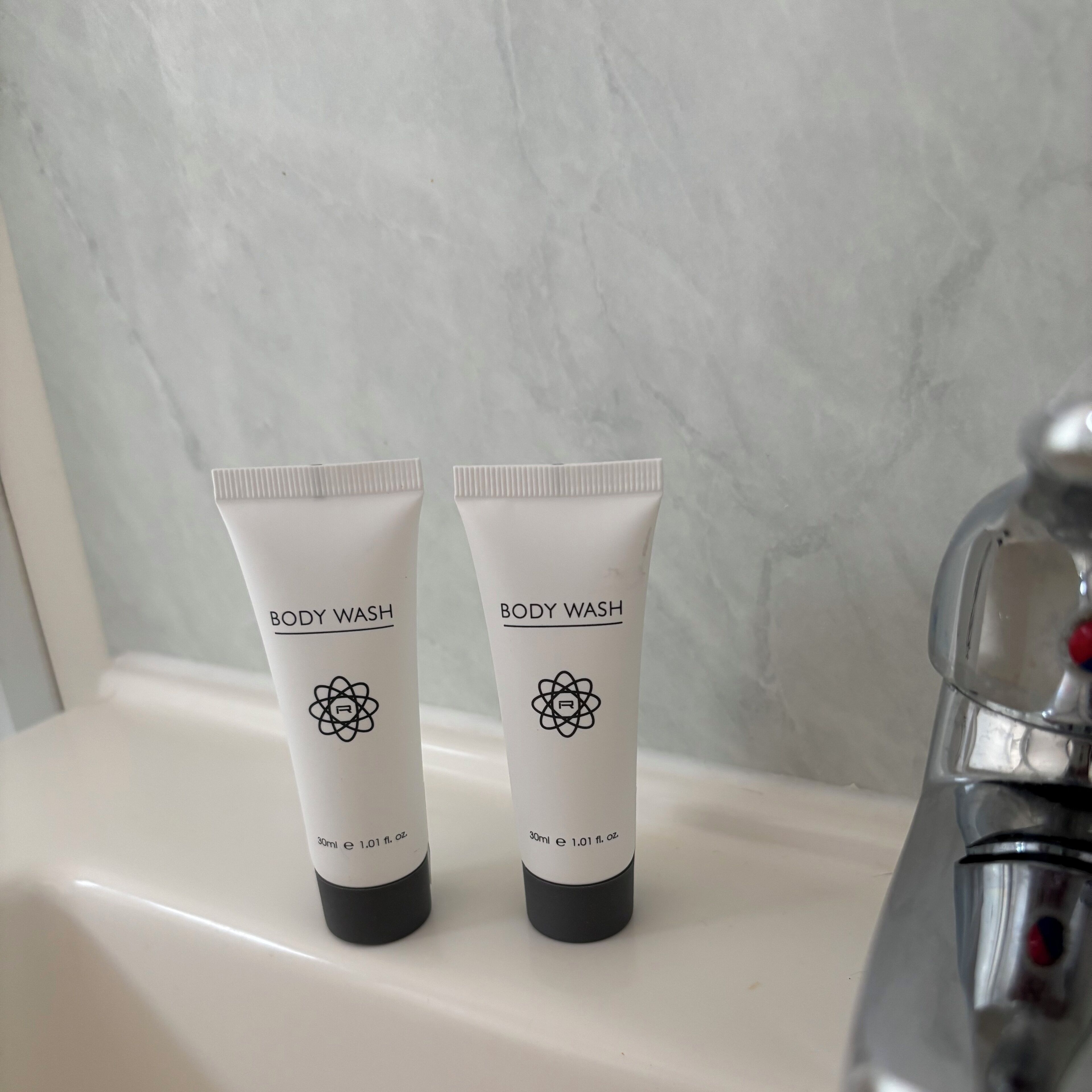 Dos envases de gel per al cos sobre un envair de bany.