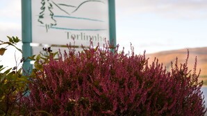 A sign with a landscape illustration and the name "Torlinha". - Torlinnhe Guesthouse (Fort William)