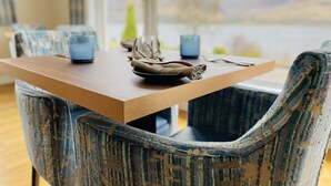 A dining table with chairs, a vase, and a bowl. - Torlinnhe Guesthouse (Fort William)