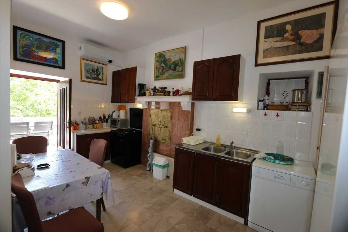 Une cuisine compacte dotée de meubles en bois, d’un lave-vaisselle et d’un coin repas avec une table et des chaises.