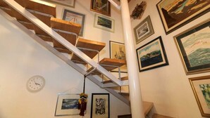 A staircase with wooden steps and white railings, surrounded by framed pictures on the walls. - Apartment Ljustina (Silo - island Krk)