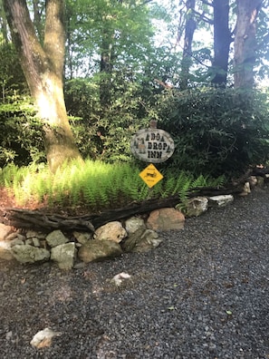 Welkomstbord voor Drop Inn, omgeven door dicht bos en een bord met een natuurreservaat.