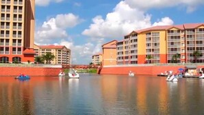 Un hotel sul lungofiume con diversi edifici, un fiume tranquillo e imbarcazioni.
