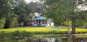 Guests can relax on the porch overlooking the serene lake surrounded by lush greenery.