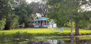 Guests can relax on the porch overlooking the serene lake surrounded by lush greenery.