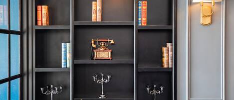 A bookshelf with books and decorative items, a lamp, and a plant.