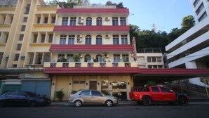 A multi-story hotel with a red roof and balconies, featuring a sign that reads "HOTEL LONDON". - Hotel O London (Sandakan)