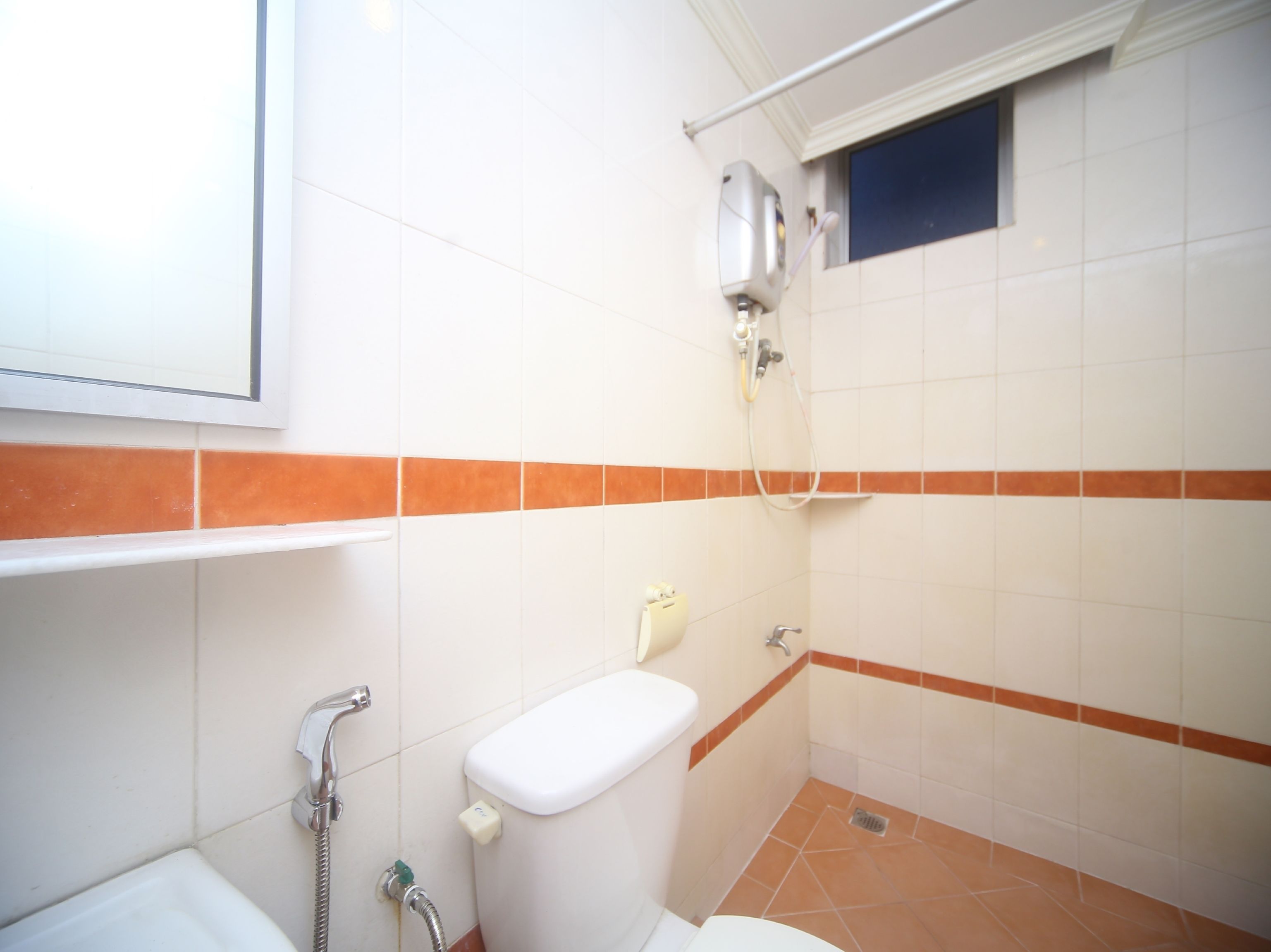 A small bathroom with a toilet, a shower, and a sink.