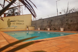 Una piscina al aire libre, sillones reclinables de piscina