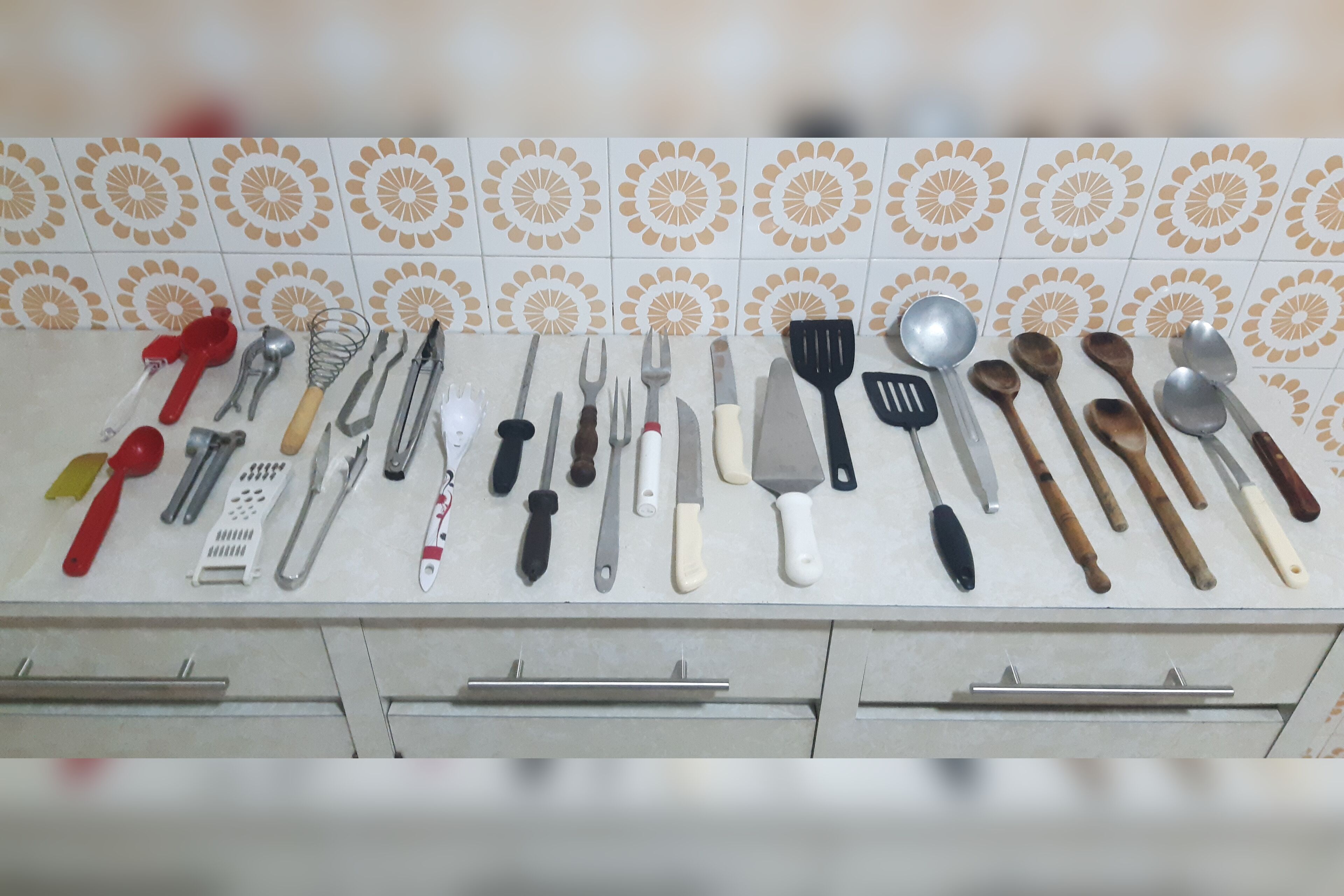 Un plan de travail de cuisine avec divers ustensiles et outils de cuisine, disposés de manière ordonnée.