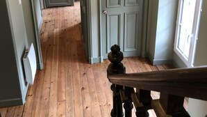 Una escalera de madera que lleva a una habitación con una puerta y una ventana.