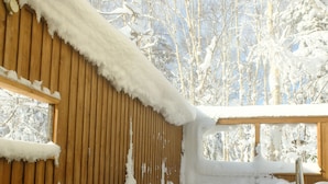 A wooden cabin with a snow-covered exterior and a clear glass pool. - K's House Hokkaido - Asahidake Onsen Hostel (Higashikawa)