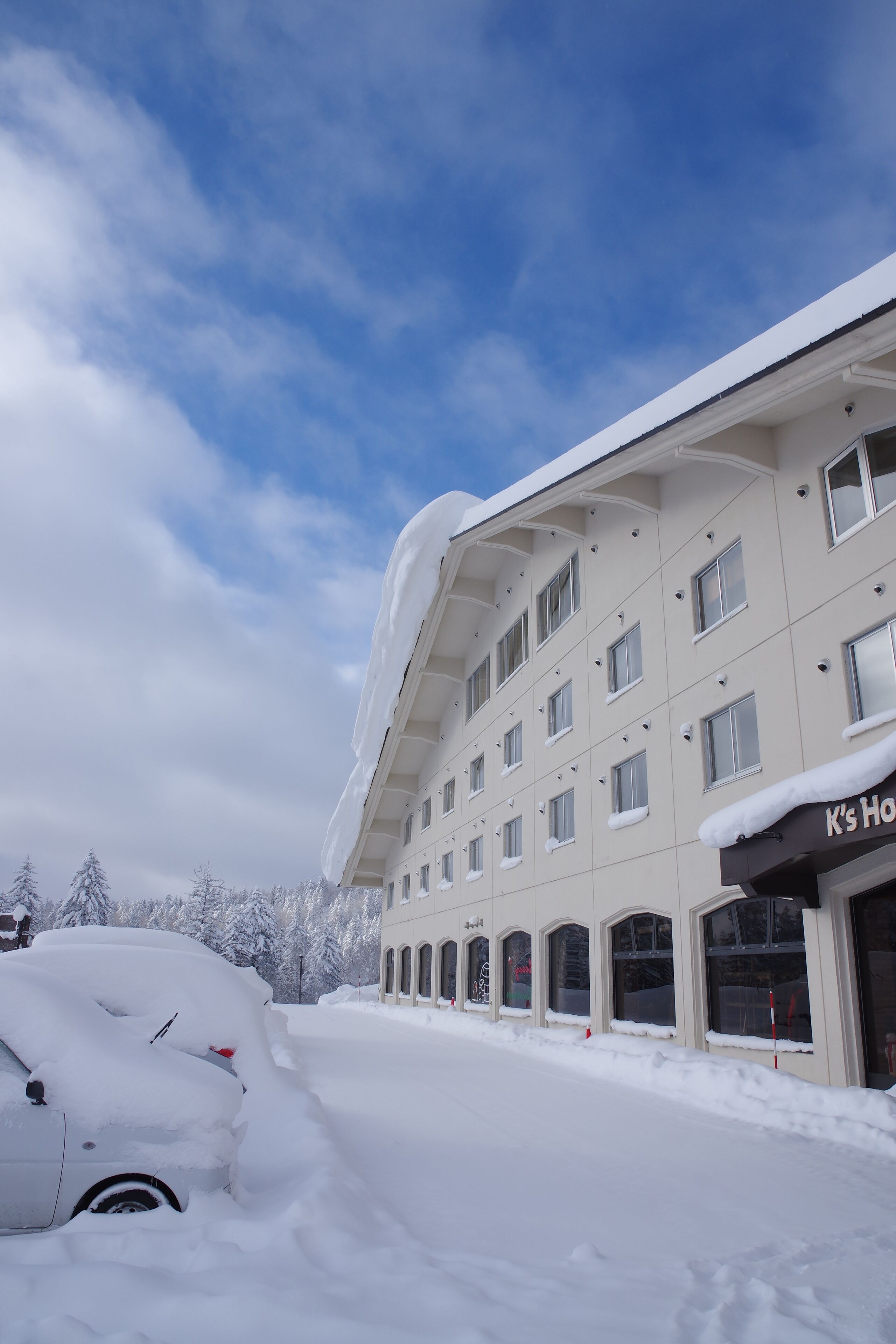 A hotel with a snow-covered exterior and a partially visible sign that reads "K's Hotel".