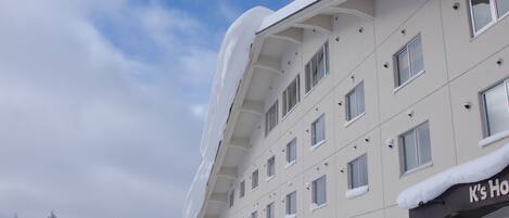 A hotel with a snow-covered exterior and a partially visible sign that reads "K's Hotel".