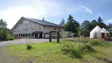 A large building with a sign for the K's House Hotel, a parking area, and a small white structure nearby.