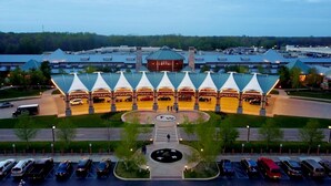 A hotel with a central courtyard, multiple parking levels, and a distinctive roof structure. - Union Pier Hidden Gem | 3 Blocks to Beach | Screened Porch & Fire Pit (Union Pier)