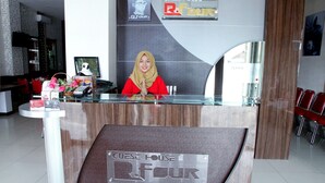 A reception desk with a sign reading "Guest House R.Four". - OYO 861 R Four Hotel (Palu)