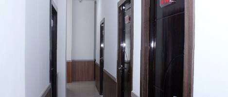 A hallway with wooden doors and white walls.
