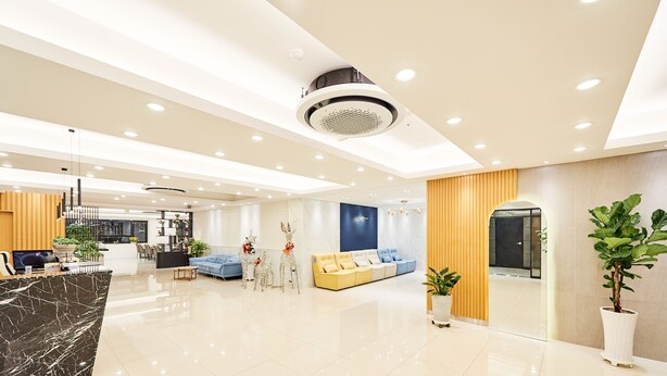 A modern hotel lobby with a marble reception desk, a blue sofa, and a yellow couch. - Seattle B Hotel (Busan)