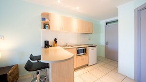 A compact kitchen with a bar area, a microwave, and a dishwasher. - Baybliss Studio 2 (Shute Harbour)