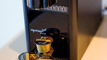 A coffee machine with four coffee pods labeled "PAULAND BLEND" and "TANNE BLEND" on a countertop.