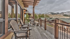 A wooden deck with Adirondack chairs, a pergola, and a view of mountains and trees. - Luxury Townhome, Gourmet Kitchen, Hot Tub, Recreation, Great Location! (Deer Valley)