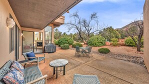 An outdoor patio with wicker furniture, a small round table, and a grill. - Santa Susana | West Sedona Townhome w/ Pool, Hot Tub & Red Rock Views (Sedona)