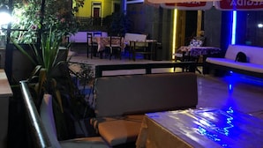 An outdoor seating area with tables and chairs, a building with a sign reading "ALGiDA", and some potted plants. - Meltem Hotel (Konyaalti)