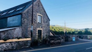 A stone building with a sign reading "SGWD GWLADYS" and a smaller sign below it. - Sgwd Gwladys (Neath)