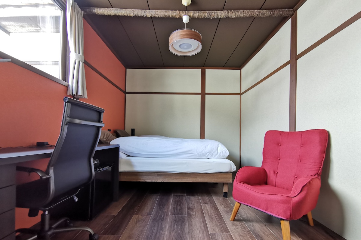 Une pièce comprenant un lit, un bureau, une chaise et une fenêtre.