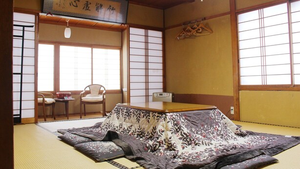 A traditional Japanese room with tatami flooring, a low wooden table, and a shoji screen door. - Zao Onsen Pension Bokunouchi (Kaminoyama)