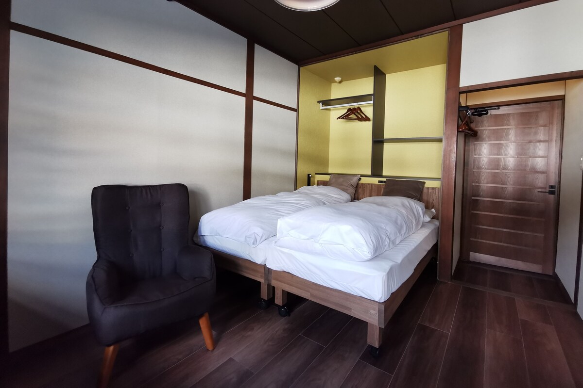 Une chambre à coucher avec un lit, une chaise, une armoire et un luminaire au plafond.