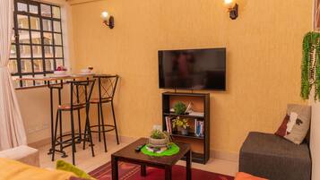 Departamento, 1 habitación | Área de sala de estar | Smart TV de 40 pulgadas con canales vía satélite y televisión