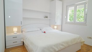 Una camera da letto con un letto, comodini, una finestra e mobili a incasso.