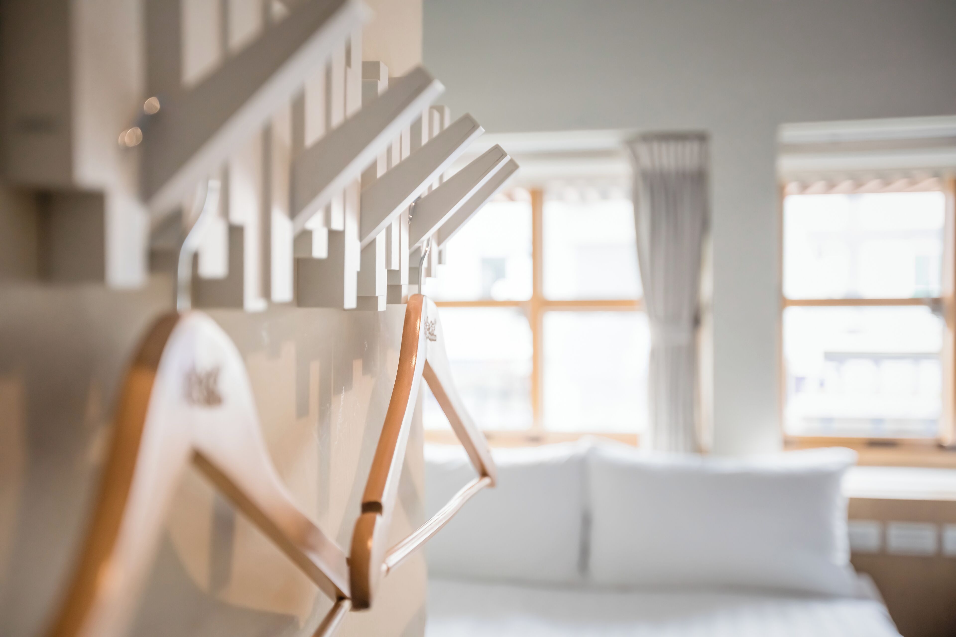 Un interior moderno con una escalera, un sofá blanco y una ventana con cortinas.
