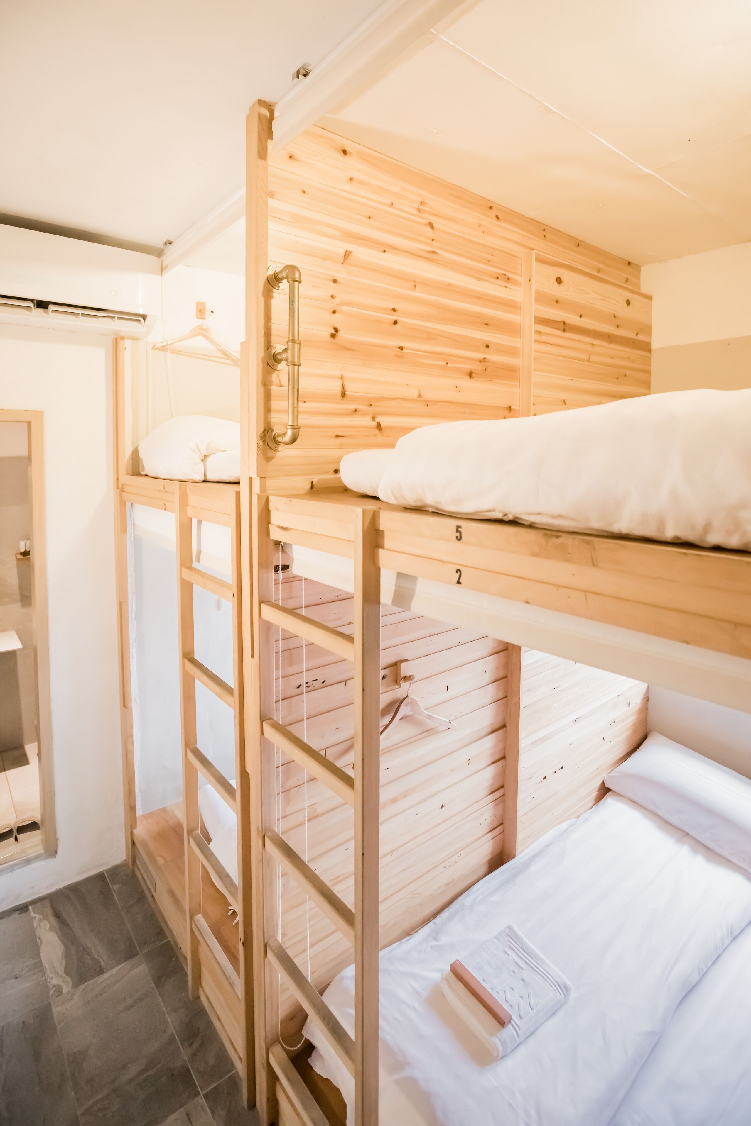 A bunk bed room with wooden walls and a tiled floor.