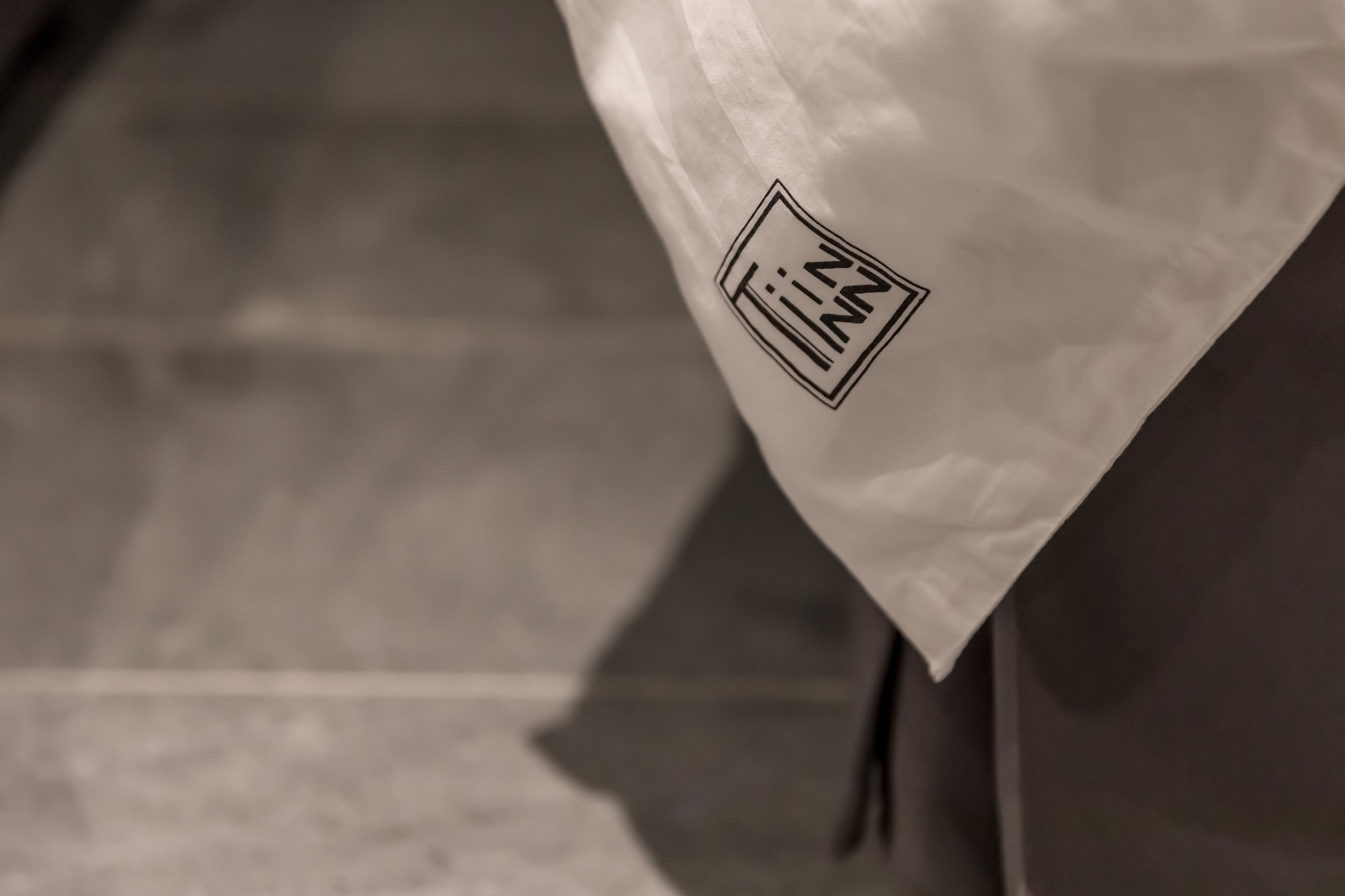 A close-up of a white paper bag with a logo that reads "Inn."