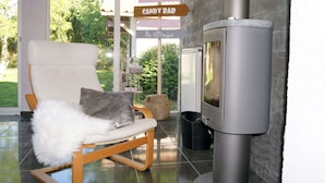 A modern living room with a fireplace, a lounge chair, and directional signs indicating amenities like a candy bar and dinner.