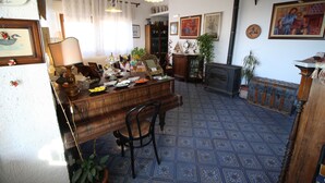 A room with a wooden dining table, chairs, a fireplace, and various decorations including framed pictures and trophies. - Bed & Breakfast Villa Rosa (Cefalù)