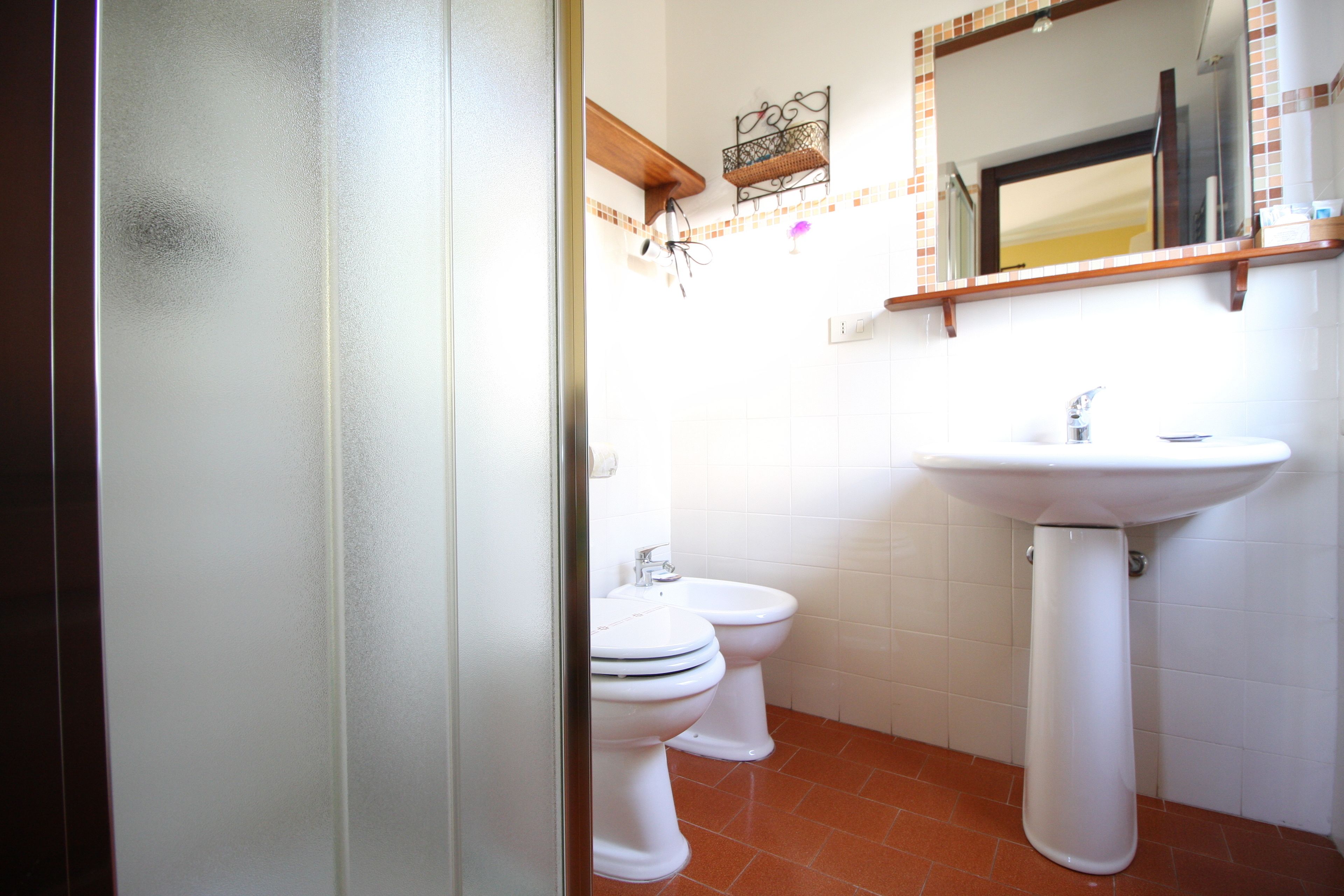 Un baño con dos inodoros, un lavabo y un espejo sobre él.