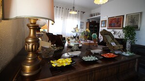 A dining area with a wooden table set with various dishes and a decorative lamp. - Bed & Breakfast Villa Rosa (Cefalù)