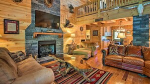 A cozy log cabin interior with a fireplace, leather sofas, and rustic decor including animal heads and antlers. - Trenton Cabin w/ Hot Tub - 14 Mi to Lookout Mtn! (Trenton)