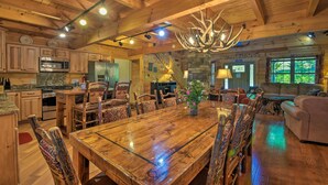 A spacious wooden interior with a large dining table, kitchen area, and cozy seating. - Trenton Cabin w/ Hot Tub - 14 Mi to Lookout Mtn! (Trenton)