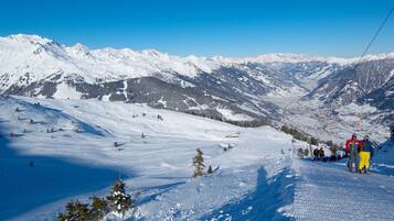 A snowy mountain landscape with ski slopes and a ski lift.