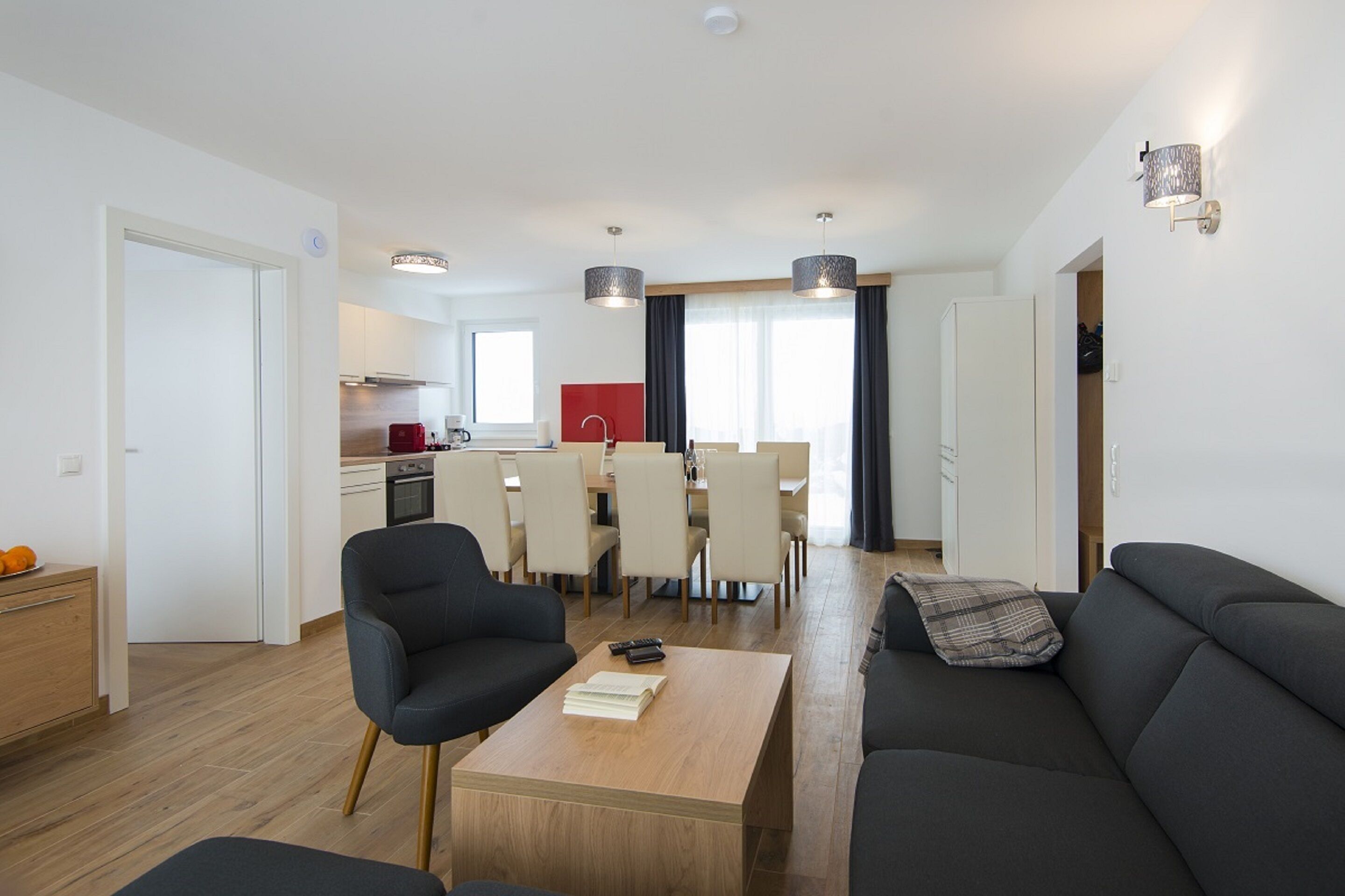 A modern apartment with a dining area, kitchen, and living room.