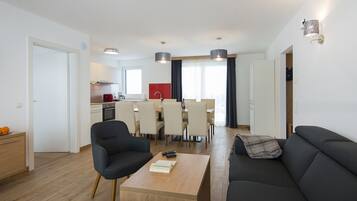 A modern apartment with a dining area, kitchen, and living room.