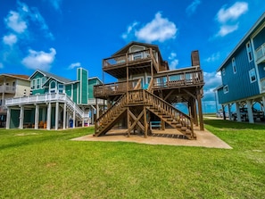 Una estructura de madera con varios niveles y escaleras, rodeada de edificios residenciales.